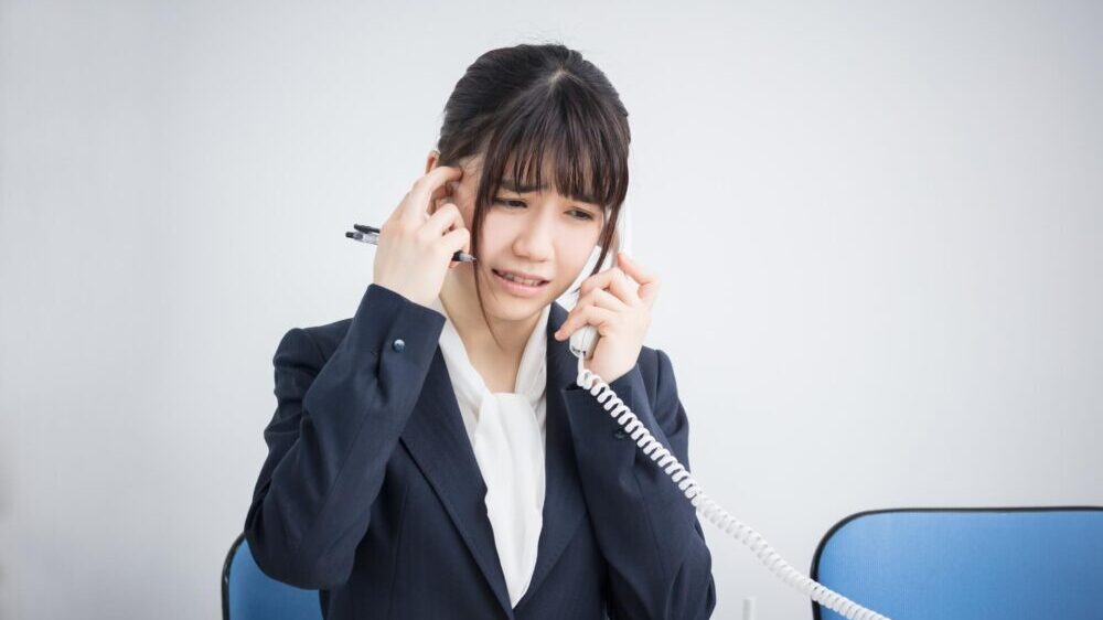 電話クレーム対応中の女性ビジネスマン